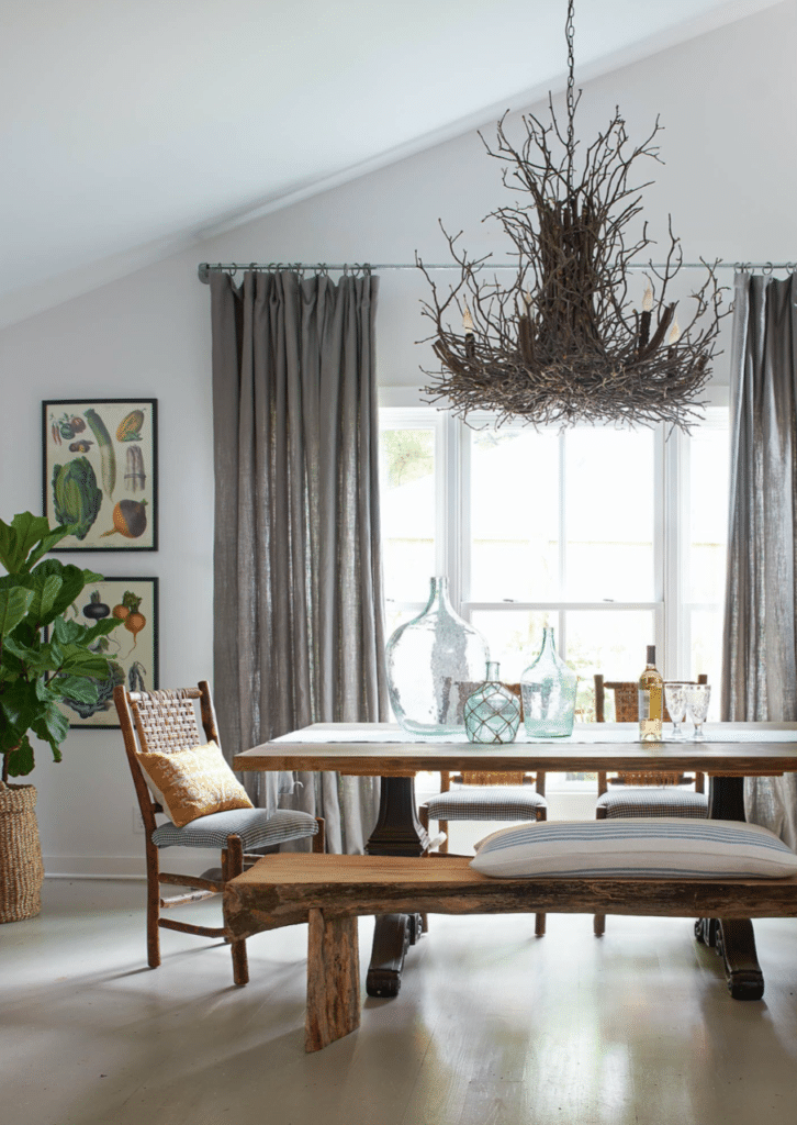 Rustic chandelier over dining table in bright, modern room.